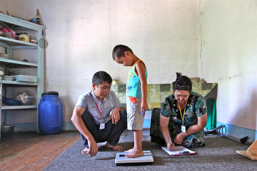 Health workers measure and record the height and weight of Erlan Bernoupereinev, 3, at his home, in Kindik Uzyak Village in the Konlikul District, Republic of Karakalpaksta