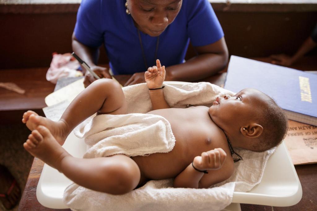 A health worker records the weight of a girl while she lies on a scale at the Kenema government hospital in Kenema, Kenema district, Sierra Leone on Monday September 23, 2013.