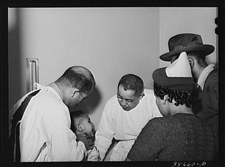Doctors examining baby whose parents have just brought him into the clinic at the Negro hospital. Chicago, Illinois. Russel Lee