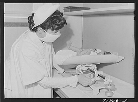 Nurse weighs baby in the nursery of the Cairns General Hospital at the FSA (Farm Security Administration) farm workers' community. Eleven Mile Corner, Arizona. Russel Lee