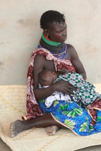 A Turkana mom breastfeeding her child as she waits to be served at a local health center.