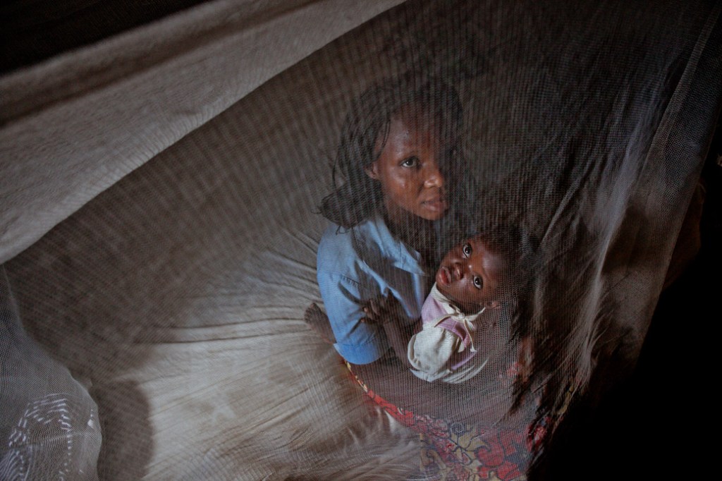 A woman and her little child under a mosquito net distributed by UMCOR in the Democratic Republic of Congo as part of the Imagine No Malaria program